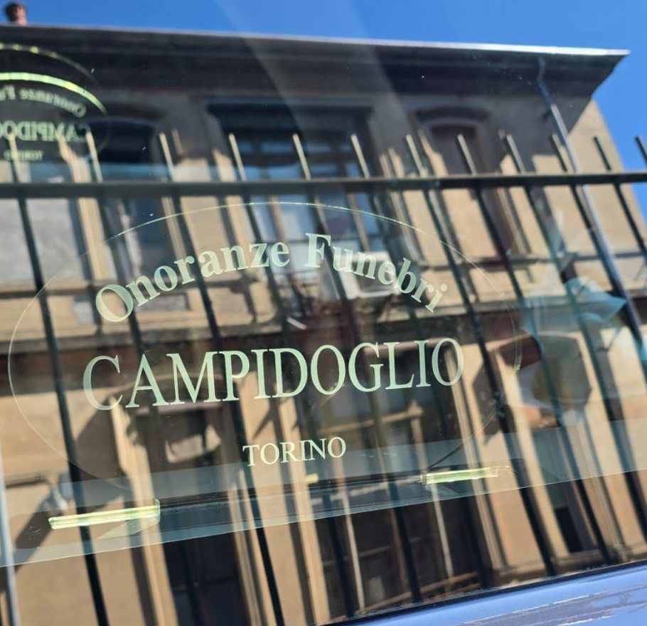 Il marchio Onoranze Funebri Campidoglio Torino sul vetro dell'auto di servizio